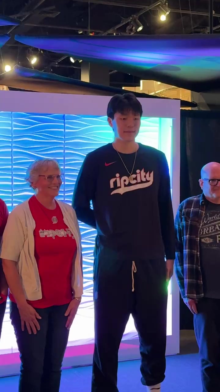 九游娱乐中心-融入球队文化！杨瀚森化身背景板 满脸微笑与球迷合影留念